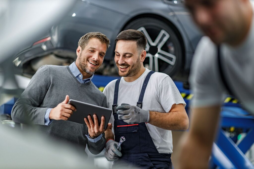 two men are looking at a tablet in a garage